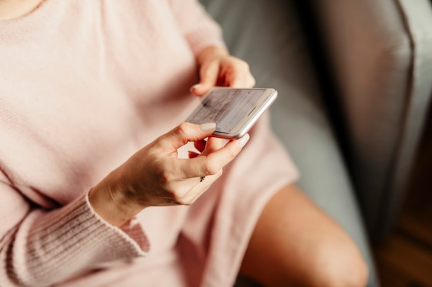 Frau, die auf einem Mobiltelefon durch soziale Medien scrollt