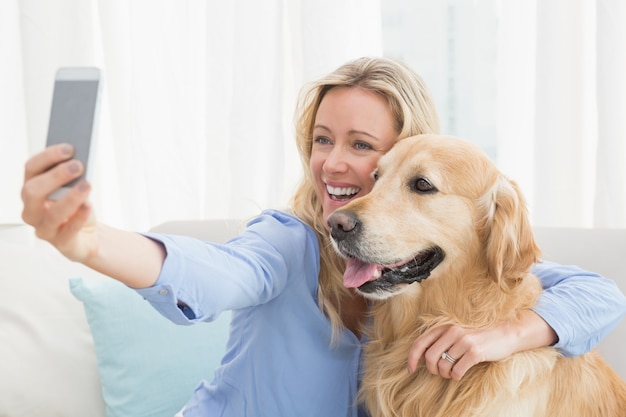 Foto frau, die auf einem sofa macht ein foto von selbst sitzt