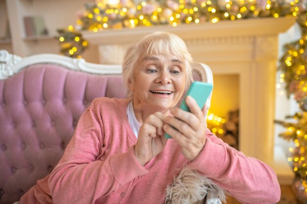 Frau, die auf einem Sofa sitzt und ein nettes Gespräch am Telefon hat