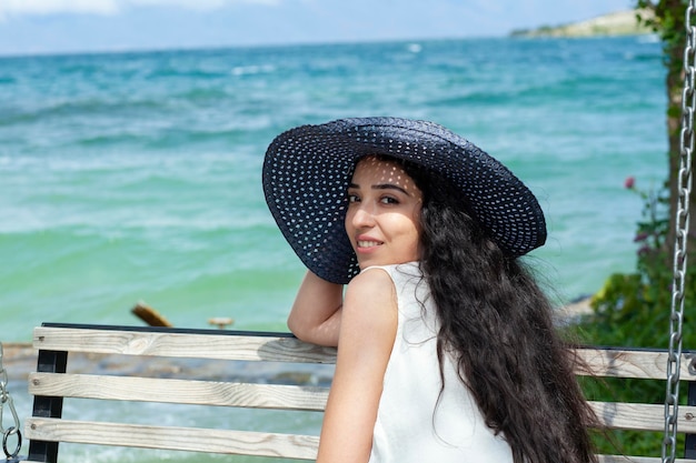 Frau, die auf einer Bank im Meer sitzt