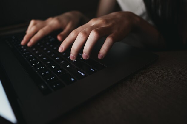 Frau, die auf einer Laptoptastatur tippt