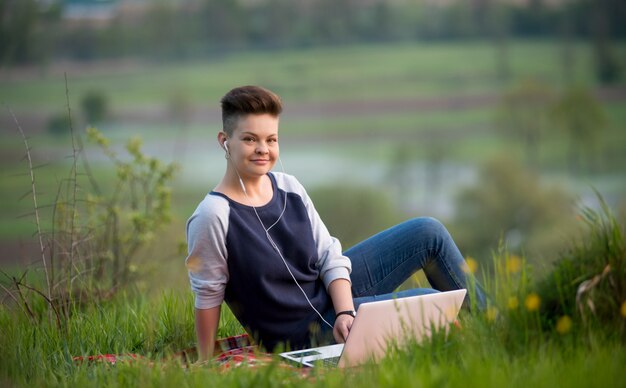 Frau, die auf ihrem Laptop tippt, der draußen arbeitet