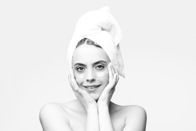 Frau, die Augenflecken aufträgt, porträtiert Schönheitsmädchen mit Handtuch auf dem Kopf