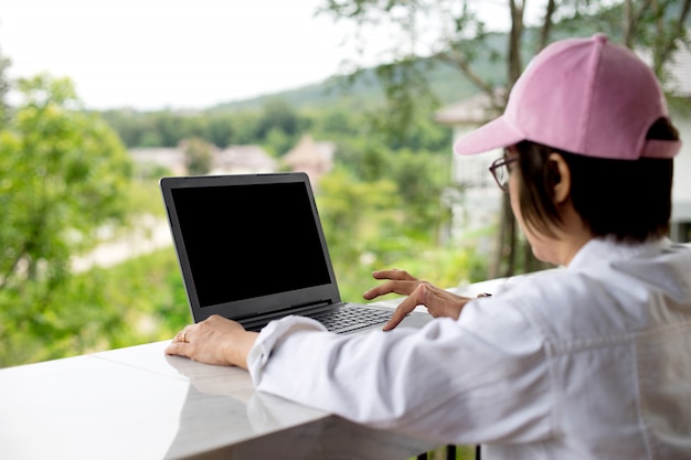 Frau, die aus ihrem Büro heraus ausarbeitet, wenn sie vaction im Erholungsort hat, aber in ihrem Laptopkonzept freiberuflich arbeiten kann