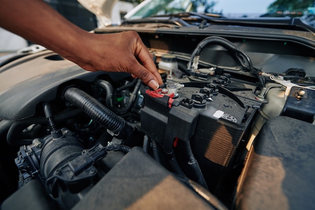 Frau, die Autobatterie prüft