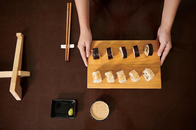 Frau, die Bambus-Sushi-Brett hält