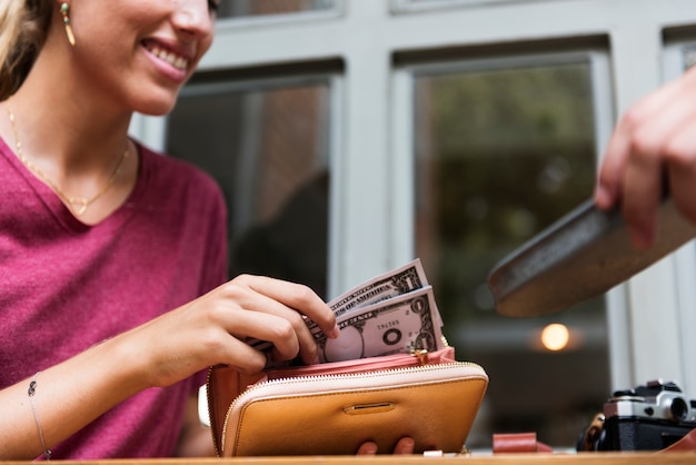 Foto frau, die bargeld für rechnungsrestaurant zahlt