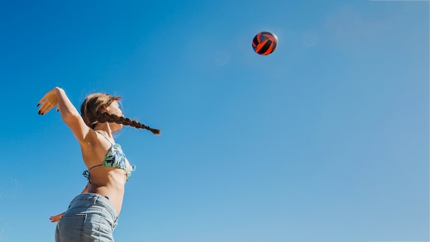 Frau, die Beach-Volley-Ansicht von unten spielt