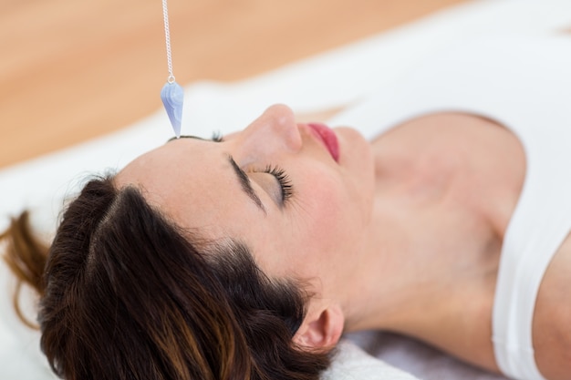 Foto frau, die beim lügen auf dem boden hypnotisiert wird