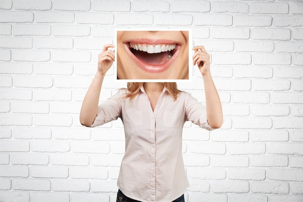 Frau, die Bild mit großem Lächeln hält. Konzeptfoto auf dunklem Hintergrund