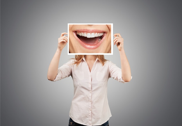 Frau, die Bild mit großem Lächeln hält. Konzeptfoto auf dunklem Hintergrund