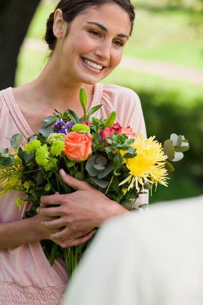 Frau, die Blumen hält, die ihr gegeben worden sind