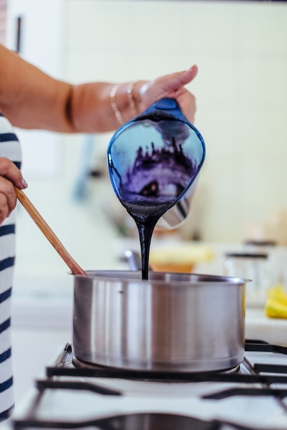 Frau, die Brombeermarmelade kocht