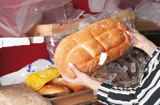 Frau, die Brot aus einem Supermarkt wählt