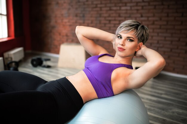 Frau, die Übungen mit fitball in der Fitness-Turnhalle macht