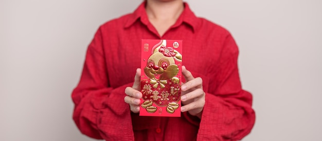 Foto frau, die chinesischen roten umschlag mit goldenem kaninchen hält und wortgeldgeschenk für frohe feiertage des neuen mondjahres segnet chinesischer satz bedeutet glück gesund glücklich und wohlhabend