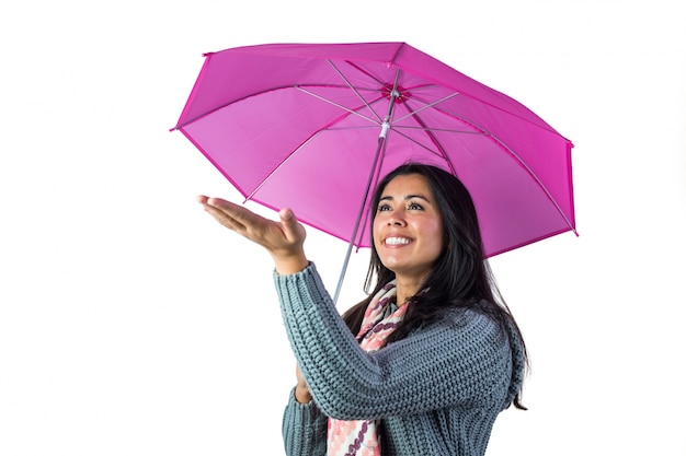 Frau, die das Wetter von unter ihrem Regenschirm überprüft