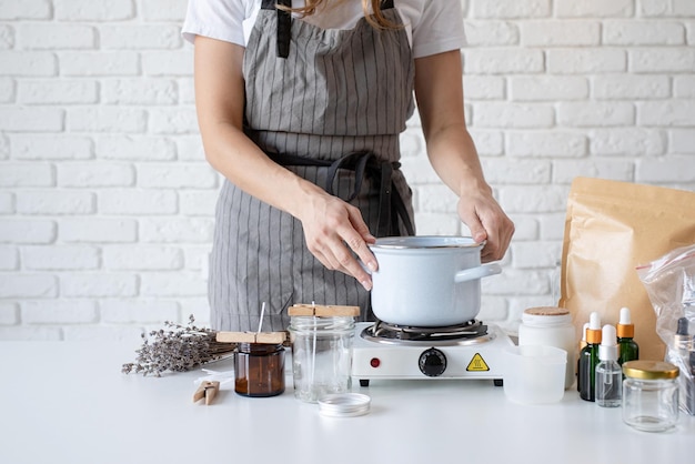 Frau, die dekorative Aromakerze am Tisch in Nahaufnahme macht