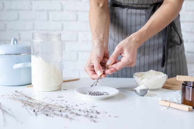 Frau, die dekorative Aromakerze am Tisch in Nahaufnahme macht