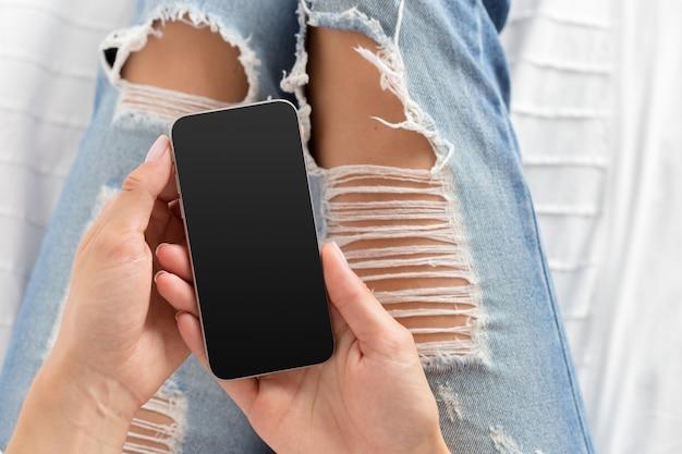 Frau, die den Handy auf dem Bett überprüft