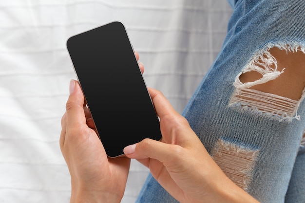 Foto frau, die den handy auf dem bett überprüft