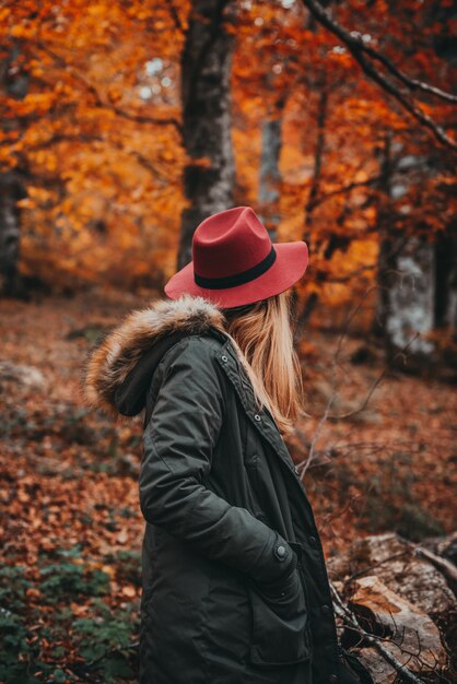 Frau, die den herbstlichen Wald erforscht