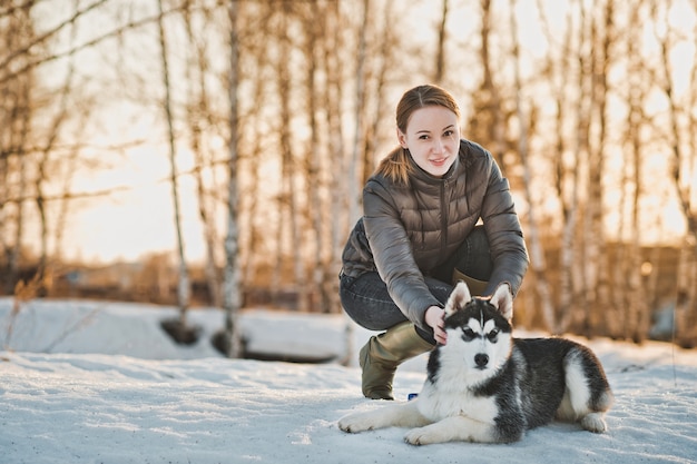 Frau, die den Hund im Winter geht