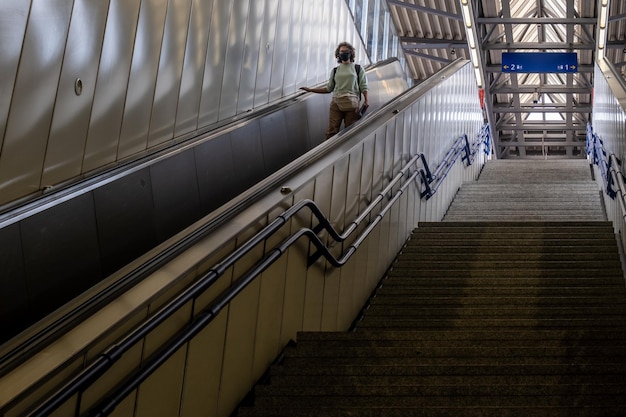 Frau, die die U-Bahn-Rolltreppe in Wien hinuntergeht