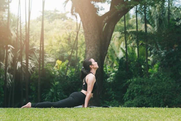 Frau, die draußen Yoga praktiziert