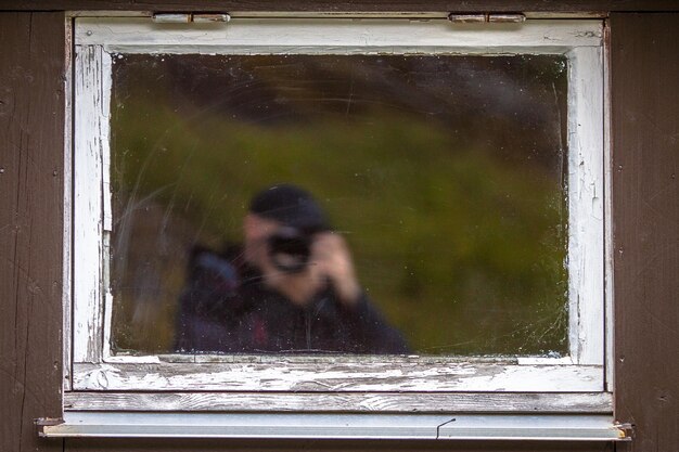 Frau, die durch das Fenster schaut