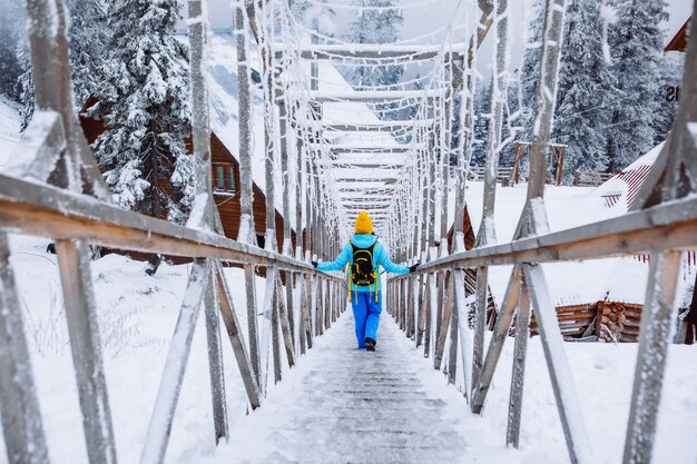 Frau, die durch eisige verschneite Treppe im Winterbergresortbergresort geht