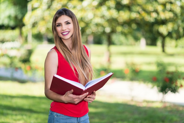 Frau, die ein Buch im Freien liest