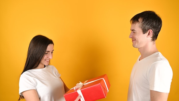 Frau, die ein Geschenk von ihrem Geliebten auf Gelb erhält