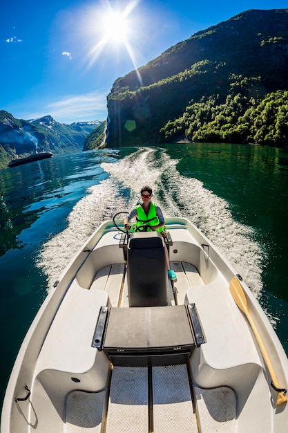 Frau, die ein Motorboot fährt. Geirangerfjord, schöne Natur Norway.Summer Urlaub.