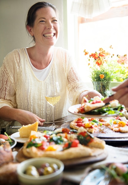 Frau, die ein Pizzaabendessen genießt