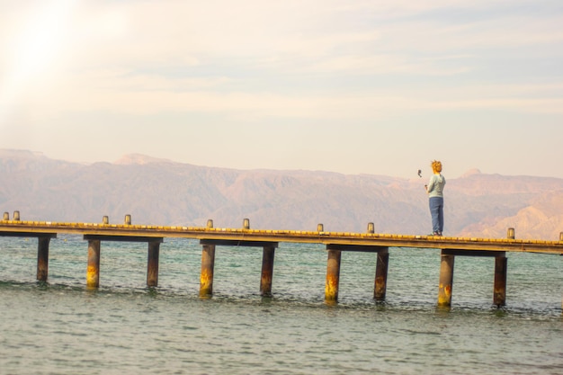 Frau, die ein Selfie auf einem Pierdock über dem Roten Meer macht, exotische Strandreise und Tourismus