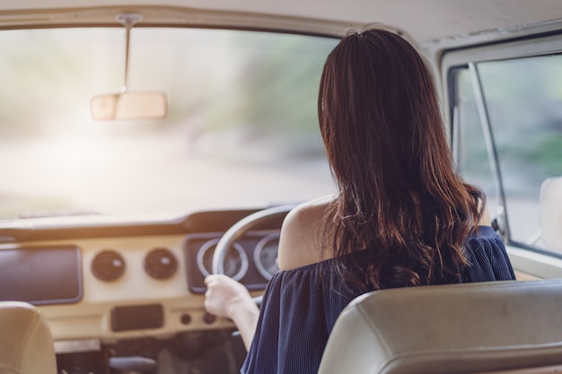 Frau, die ein Weinleseauto antreibt