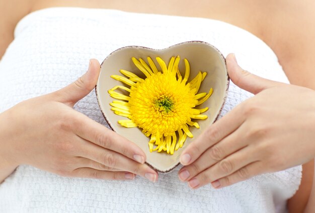 Frau, die eine Blume in ihren Händen anhält