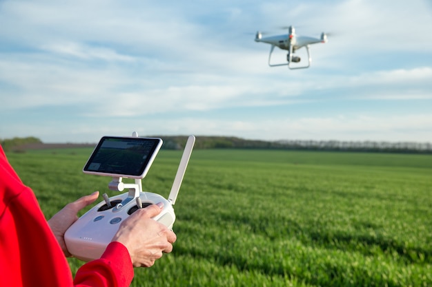 Frau, die eine Drohne am Feld fliegt