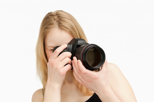 Frau, die eine Fotografie mit einer einäugigen Spiegelreflexkamera macht