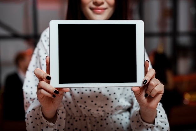 Foto frau, die eine tablette an einer silvesterparty hält