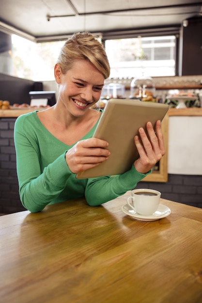 Frau, die eine Tablette sitzt und lächelt