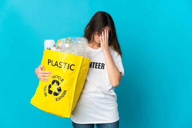 Frau, die eine Tasche voller Flaschen hält, um auf Blau mit müde und krankem Ausdruck zu recyceln