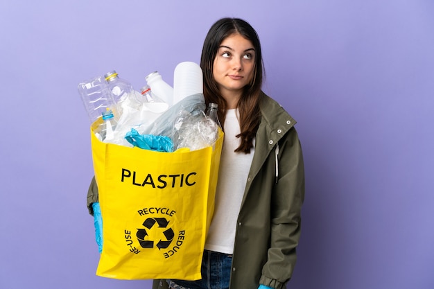 Frau, die eine Tasche voller Plastikflaschen hält, um zu recyceln