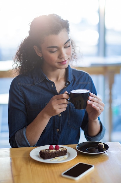 Frau, die eine Tasse Kaffee im Kaffeehaus hat