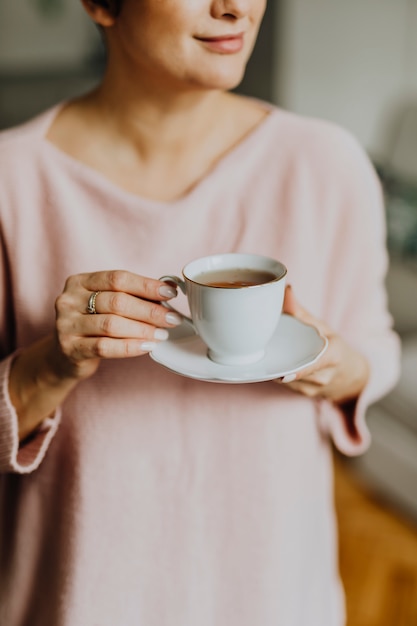 Frau, die eine Tasse Tee anhält