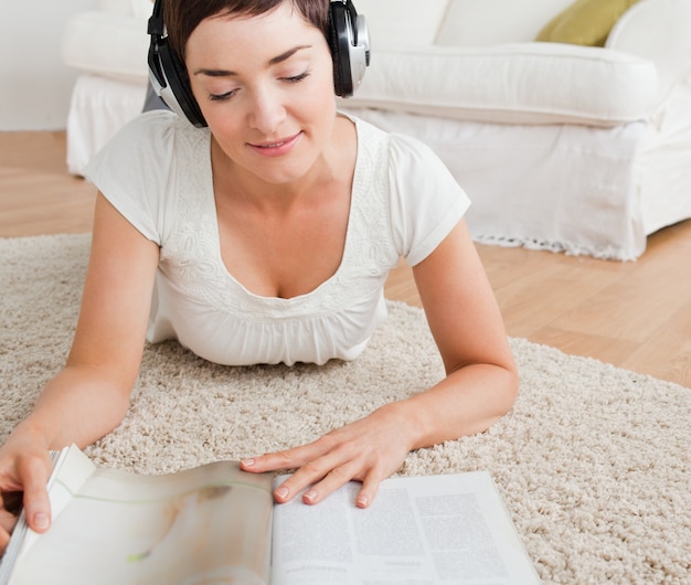 Frau, die eine Zeitschrift beim Genießen etwas Musik liest