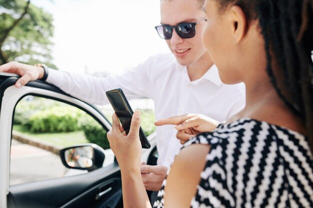 Foto frau, die einem fahrer online-bestellung zeigt