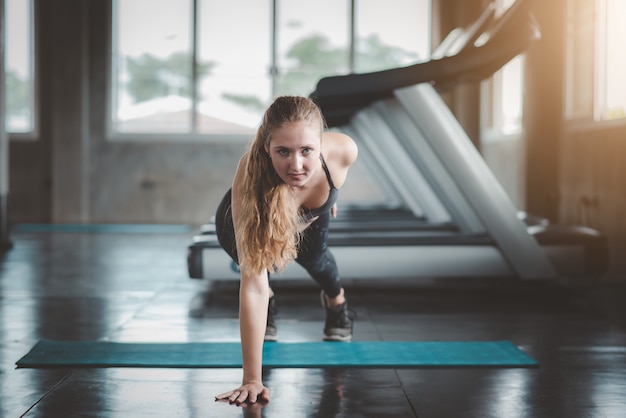 Frau, die einen Hand Liegestütz im Fitness-Studio tut