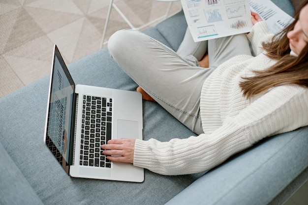 Frau, die einen Laptop verwendet, um mit Finanzdaten zu arbeiten